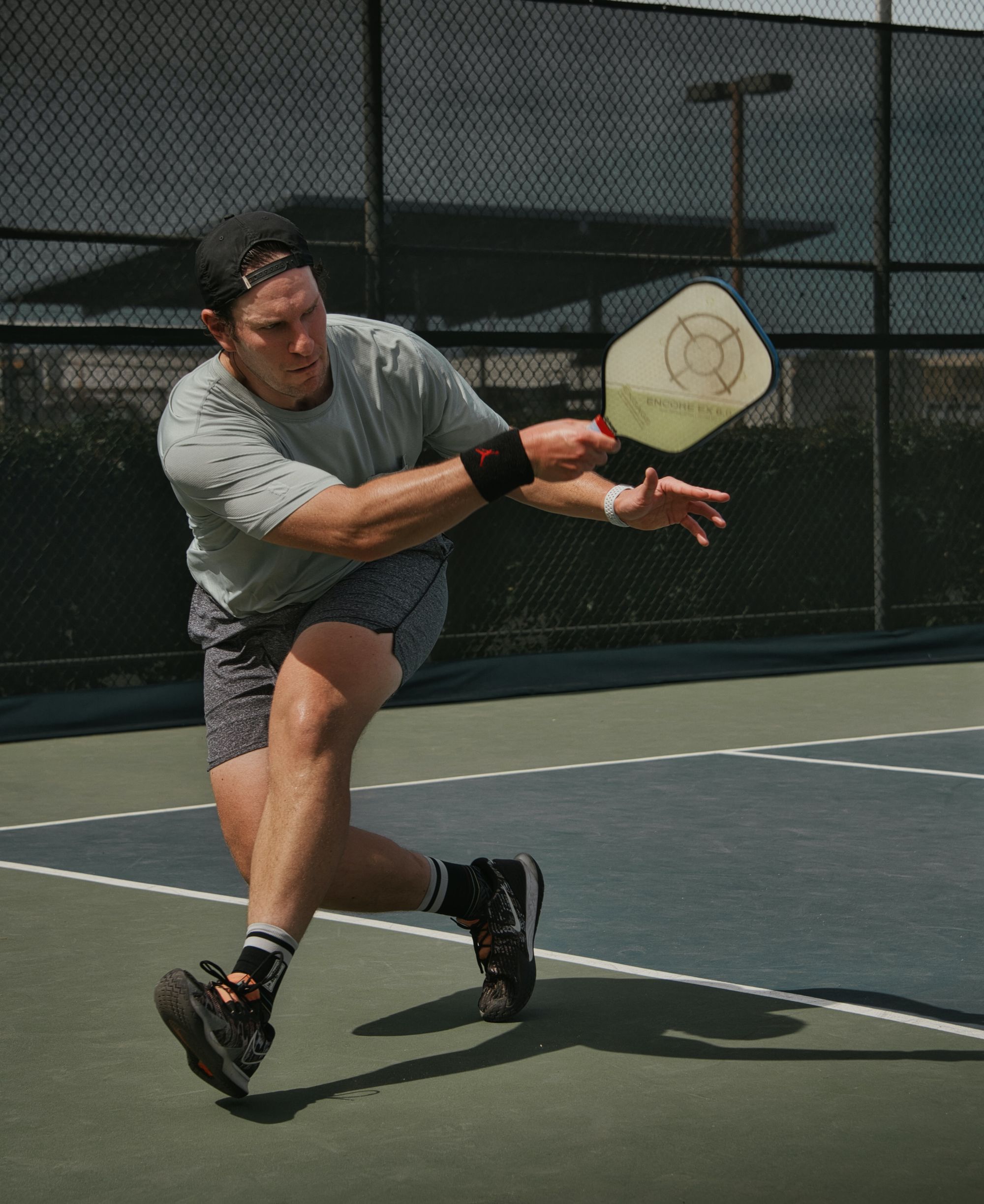 Two people playing pickleball on a professional pickleball association court